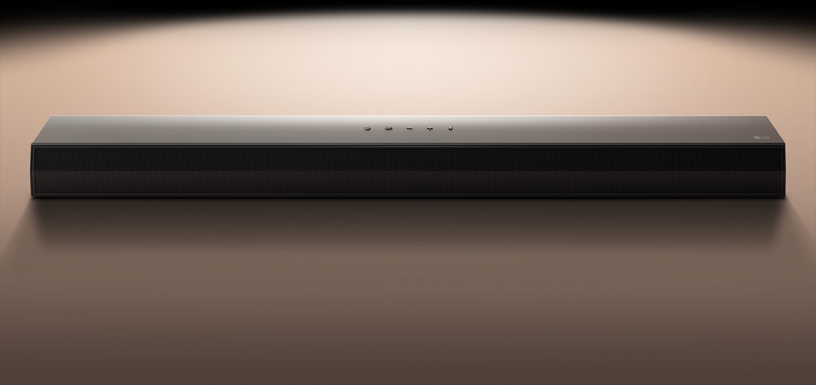 Звуковая панель LG&nbsp;Soundbar на черном фоне, подсвеченная прожектором. 