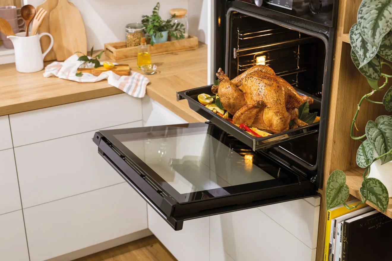 Gorenje BO6735E05X встроенный в кухонный гарнитур с открытой дверцей и блюдом внутри