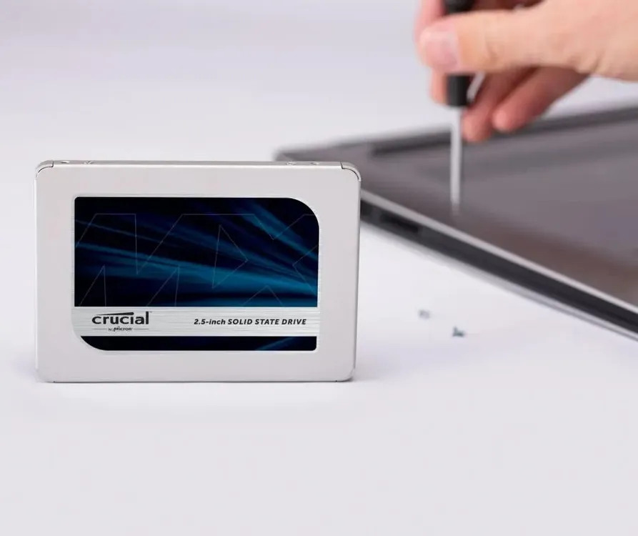 Crucial MX500 1TB 2.5 SATA SSD в руке — вид спереди белый корпус